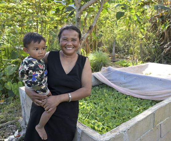 LAOS, Provinz Salavan, ACD Projekt, Dorf Pasing, Frau Enang Khaikeo "Me Noy" mit jüngstem Sohn Bounme, 2 Jahre, an Ihrem Fischteich, der von ACD gefördert wurde