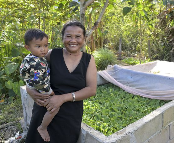LAOS, Provinz Salavan, ACD Projekt, Dorf Pasing, Frau Enang Khaikeo "Me Noy" mit jüngstem Sohn Bounme, 2 Jahre, an Ihrem Fischteich, der von ACD gefördert wurde