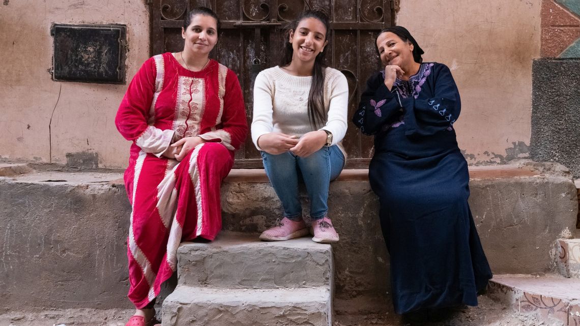 Drei Frauen sitzen an Steinwand