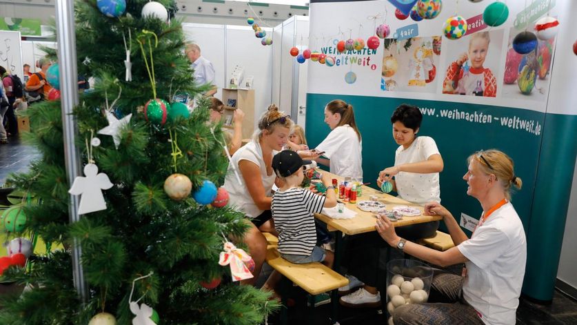 Am Stand der Kinderaktion „Weltweit Weihnachten“ gestalten Kinder Weihnachtskugeln aus einem Projekt in Indien.