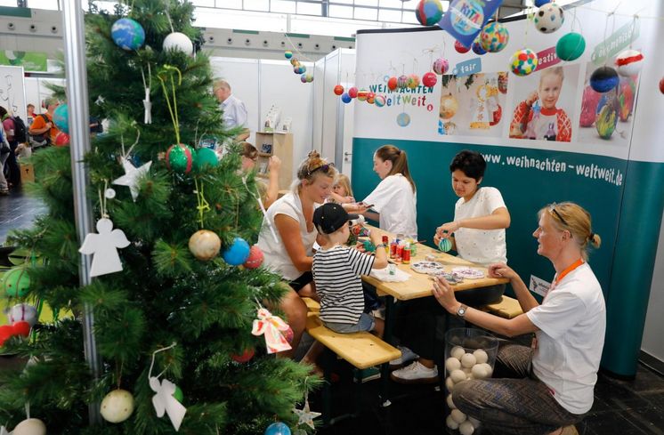 Am Stand der Kinderaktion „Weltweit Weihnachten“ gestalten Kinder Weihnachtskugeln aus einem Projekt in Indien.