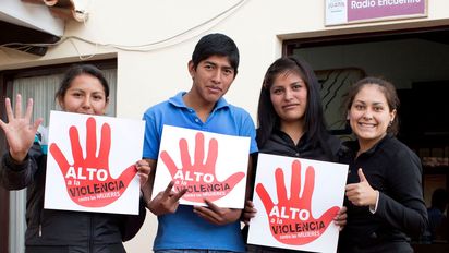 Auszubildende Jimena Arancibia, Janeth Partes Amachuy, Pablo Cruz und Lourdes "Luli" Lara halten Plakate in die Kamera