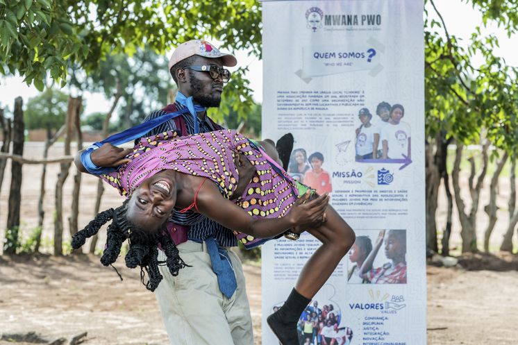 Szene aus dem Theaterstück, in dem es darum geht, dass ein junger Mann ins Dorf kommt, Reichtum vorspielt, und der Mutter quasi ihre Tochter abkauft, welche er später schwanger sitzen lässt. Leider oft Realität in einer Gegend, in der Armut herrscht, die Jugend jedoch von einer besseren Zukunft träumt. Das Stigma früher Schwangerschaft lastet stark, das Thema ist tabuisiert. In Sueja, eine halbe Stunde von Saurimo entfernt und gelegen nahe der Diamantenmine Catoca, leben 850 Einwohner hauptsächlich vom Ackerbau. Heute sind fünf Schauspieler aus Saurimo gekommen, um im Auftrag der „Brot und die Welt“-Partnerorganisation Mwana Pwo unter der Leitung von Elias Copesala ein Theaterstück zur Aufklärung über das Thema Früherverheiratung von Kindern aufzuführen.