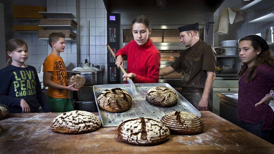 DEU, Deutschland, Berlin, 22.09.2014: Im Rahmen der  Aktion: "5.000 Brote – Konfis backen Brot für die Welt"  backt Bischof Markus Dröge mit Konfirmanden in der KuchenRausch's Feinbäckerei in Berlin - Friedrichshain Brote.Unter dem Motto: „5.000 Brote – Konfis backen Brot für die Welt", startet die Aktion  von Handwerk und Bäckerinnung zu Gunsten von Brot für die Welt. Mit den Erlösen werden Bildungsprojekte von Brot für die Welt  in Ghana, Kolumbien und Bangladesch unterstützt.(Hermann Bredehorst/Brot für die Welt)|September. 24. 2014, Germany, Berlin, Berlin:  5.000 Brote – Konfis backen Brot für die Welt  |