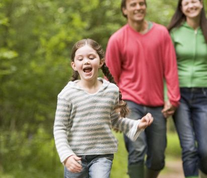 German Family is walking through an forest, holding hands