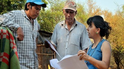 eine Frau erklärt zwei Männern etwas