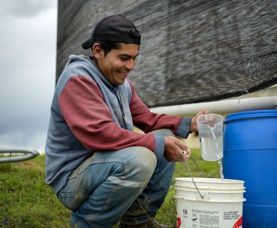 David Velázquez schöpft Wasser aus dem Kanister unter dem Nebelfänger