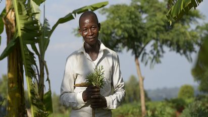 Isaya Mwita auf seiner Farm vor Bananenpflanzen