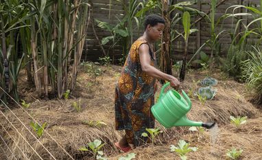 Joy Kamusiime, 38, bewässert den Gemüsegarten ihres Hauses im Dorf Kikunda 1 im Distrikt Rwampara. Projektpartner: ACORD - Agency for Cooperation in Research and Development