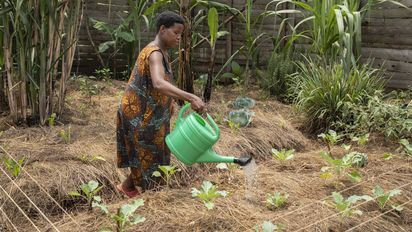 Joy Kamusiime, 38, bewässert den Gemüsegarten ihres Hauses im Dorf Kikunda 1 im Distrikt Rwampara. Projektpartner: ACORD - Agency for Cooperation in Research and Development