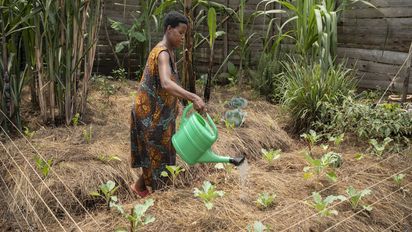 Joy Kamusiime, 38, bewässert den Gemüsegarten ihres Hauses im Dorf Kikunda 1 im Distrikt Rwampara. Projektpartner: ACORD - Agency for Cooperation in Research and Development