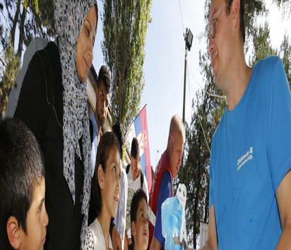 Michael Frischmuth Mitarbeiter der Diakonie Katastrophenhilfe übergibt zwei Versorgungspaket an eine Flüchtlingsfamilie.