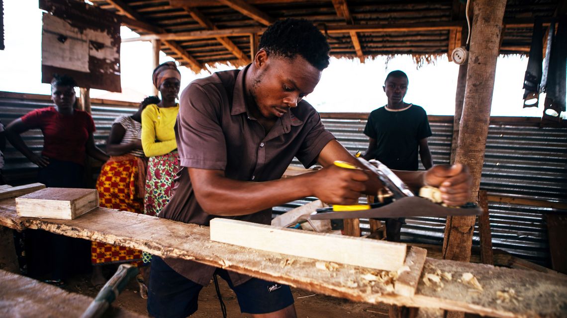 Einer der Mitarbeiter des Tischlers Issa Saide hobelt am 6. Oktober 2025 in seiner Werkstatt in Corrane ein Tischbein.Projektpartner: CEDES