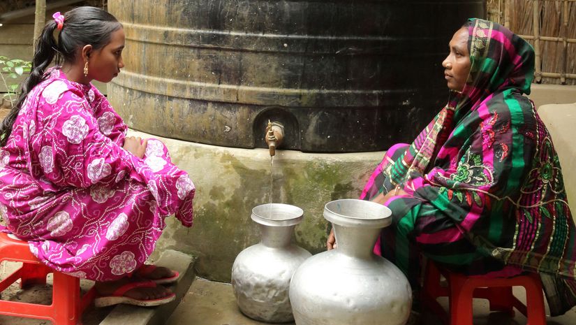 Aklima Begum und ihre Tochter Mizanur holen Wasser am Regenwasserspeicher in Charlathimara