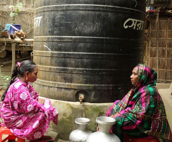 Aklima Begum und ihre Tochter Mizanur holen Wasser am Regenwasserspeicher in Charlathimara