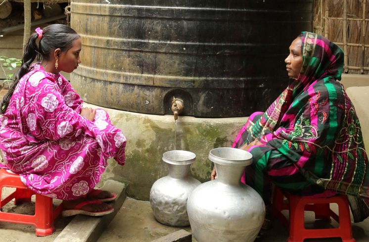 Aklima Begum (34, rechts) und ihre Tochter Mizanur (13) holen Wasser am Regenwasserspeicher in Charlathimara.Projektpartner: Christian Commission for Development in Bangladesh (CCDB)
