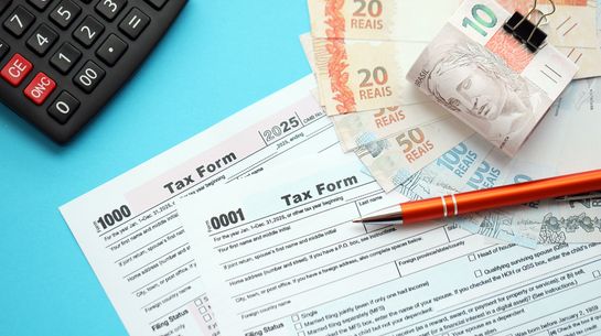 Steuerformulare und Geldscheine symbolisieren die brasilianische Steuerreform.