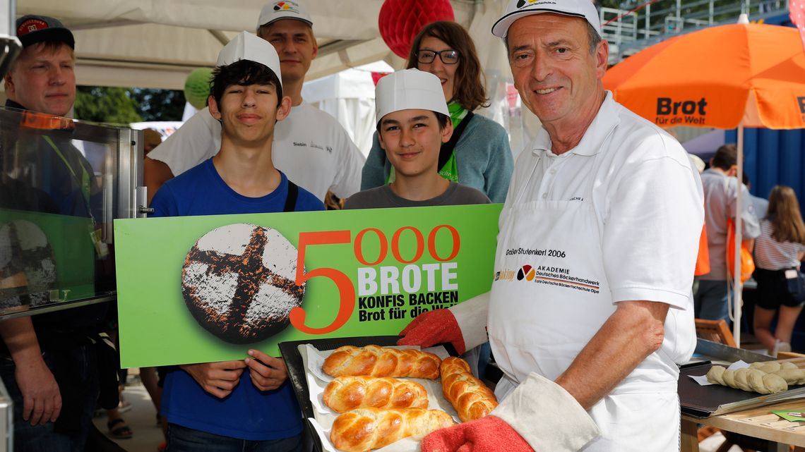 Backaktion am Stand von Brot für die Welt im Zentrum Jugend. Kinder und Jugendliche können unter Anleitung eines Bäckers hefezöpfe flechten , die direkt gebacken werden. Jede/r kann anschließend die noch warmen Brote essen.