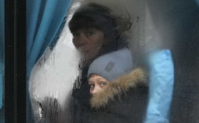 Eine Frau und ihr Sohn schauen aus einem Busfenster.