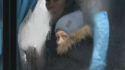 Eine Frau und ihr Sohn schauen aus einem Busfenster.