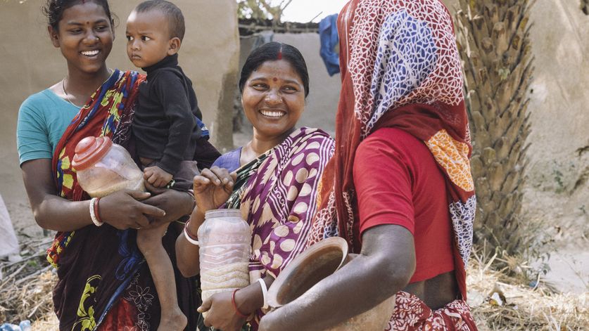 Eine Frau geht durch ein Dorf, um Reis in Rokkhagola zu abzugeben. Jede Familie bringt jede Woche ein Kilo Reis, um ihn in das Rokkhagola-System einzuzahlen.Projektpartner:  CCBVO - Centre for Capacity Building of Voluntary Organization