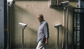 September 23, 2019, Shanghai, China - An elderly man ewalks past four newly installed security cameras in a laneway in Xuhui District. China has around 200 million surveillance cameras. (Dave Tacon/Polaris) ///