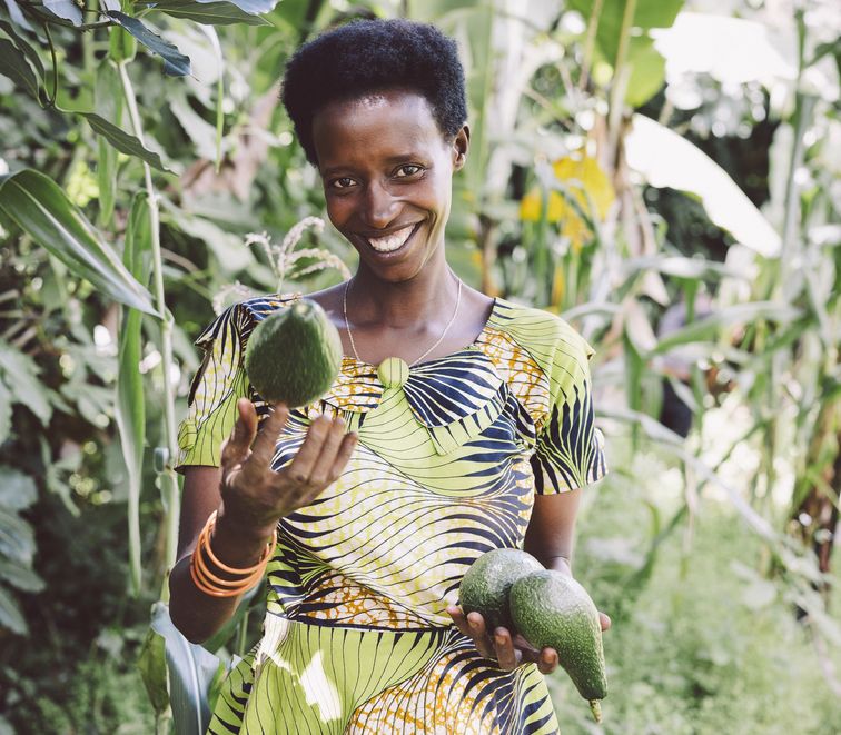 Kleinbaeuerin Claudine Hashazinyange (26) mit Avocados, die vom Baum ihres Schwiegervaters stammen.