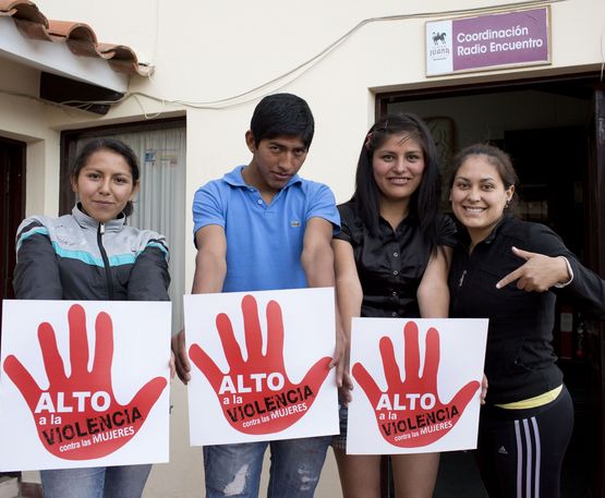 Auszubildende Jimena Arancibia, Janeth Partes Amachuy, Pablo Cruz und Lourdes "Luli" Lara halten Plakate in die Kamera