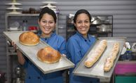 Deisy Gomez (25) und Eva Alvarenga (22) mit frisch gebackenem Brot im Workshop Bäckerei und Konditorei (Taller Panaderia y Reposteria) im Zentrum von SSPAS (Asociacion Corporacion de La Pasion – Servicio Social Pasionista) Mit dem Erlös aus der Spendenaktion „5000 Brote – Konfis backen Brot für die Welt“ wird dieses Projekt unterstützt.