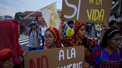 Gunas Indigenous women hold up signs tha read in Spanish "No to mining" and "Yes to life," during a march outside the National Assembly to protest against a mining contract between First Quantum Minerals of Canada and Panama's government over the Cobre Panama copper mine, in Panama City, Thursday, Oct. 19, 2023. (AP Photo/Arnulfo Franco)