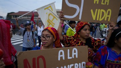 Gunas Indigenous women hold up signs tha read in Spanish "No to mining" and "Yes to life," during a march outside the National Assembly to protest against a mining contract between First Quantum Minerals of Canada and Panama's government over the Cobre Panama copper mine, in Panama City, Thursday, Oct. 19, 2023. (AP Photo/Arnulfo Franco)