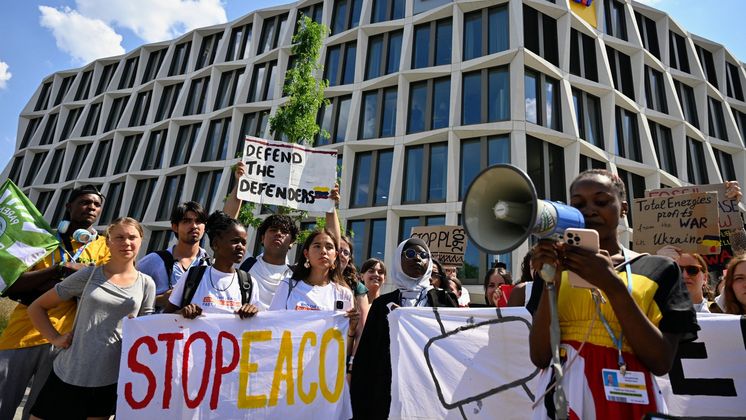 Patience Nabukalu, Klimaaktivistin aus Uganda, spricht in ein Megafon vor Greta Thunberg (hinten 2.v.l.) während einer Demonstration von Fridays for Future gegen eine geplante Öl-Pipeline in Ostafrika. Bei dem von den Klimaschützern kritisierten Projekt soll Öl in einer neuen 1443 Kilometer langen Pipeline vom Westen Ugandas durch Tansania zum Indischen Ozean gebracht werden. Umweltschützer fordern schon länger, das Projekt nicht zu finanzieren. Die Demo geht vom UN-Campus zum Hauptsitz der Postbank.