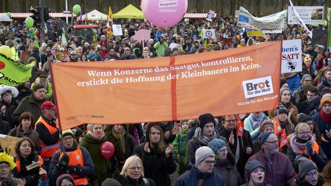 Demonstrant*innen mit einem großen Brot für die Welt Banner
