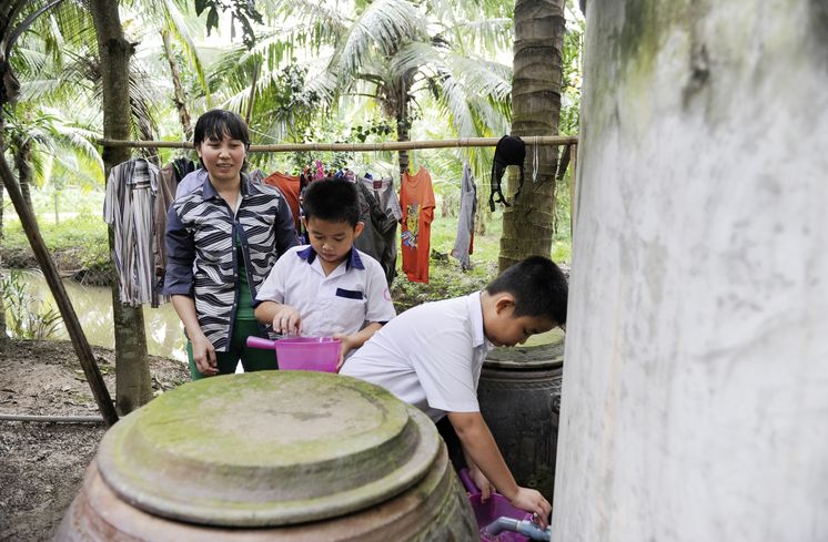 Mutter: Kam Kim Phuong (37)Zwillinge: Duong Thanh Quy (blauer Kragen)Duong Ngoc Quy , beide 8 Jahre altAsien / Vietnam / Than Tan Kommune, Mo Cay Bac District, Ben Tre Provinz