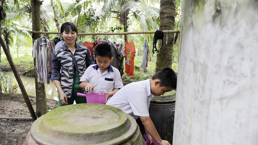 Mutter: Kam Kim Phuong (37)Zwillinge: Duong Thanh Quy (blauer Kragen)Duong Ngoc Quy , beide 8 Jahre altAsien / Vietnam / Than Tan Kommune, Mo Cay Bac District, Ben Tre Provinz