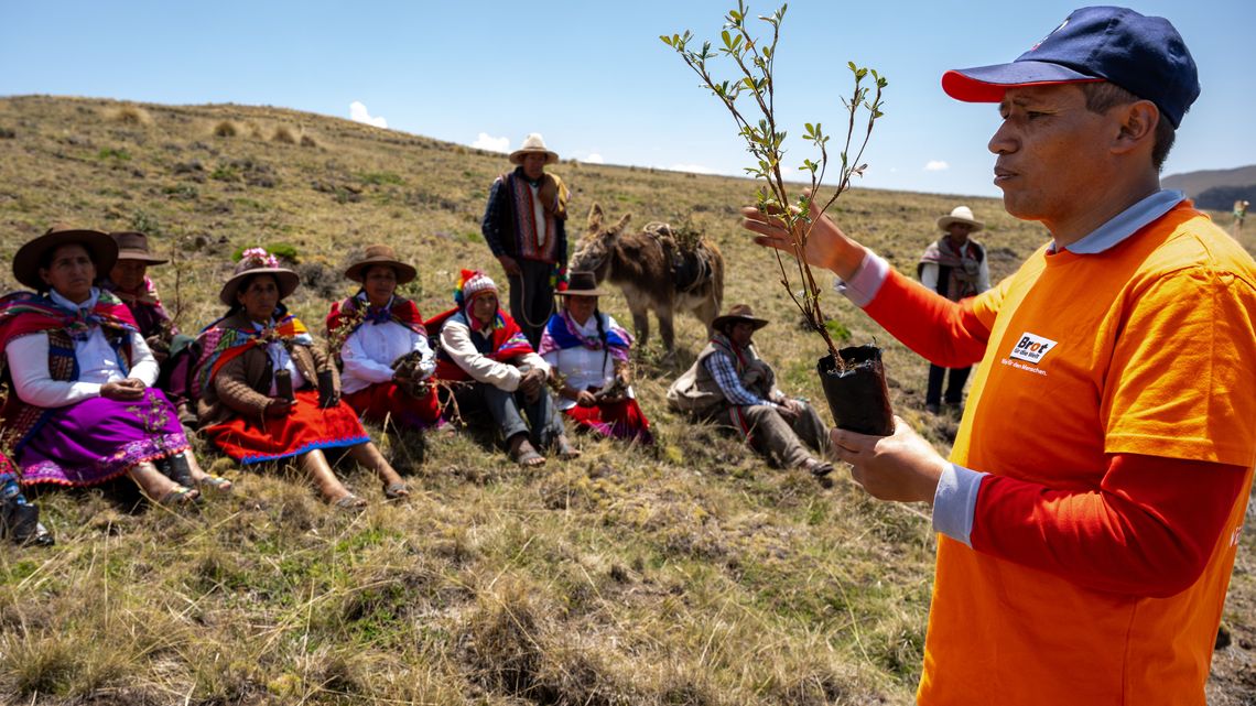 Empleado de ARARIWA con campesinos y campesinas en las tierras altas