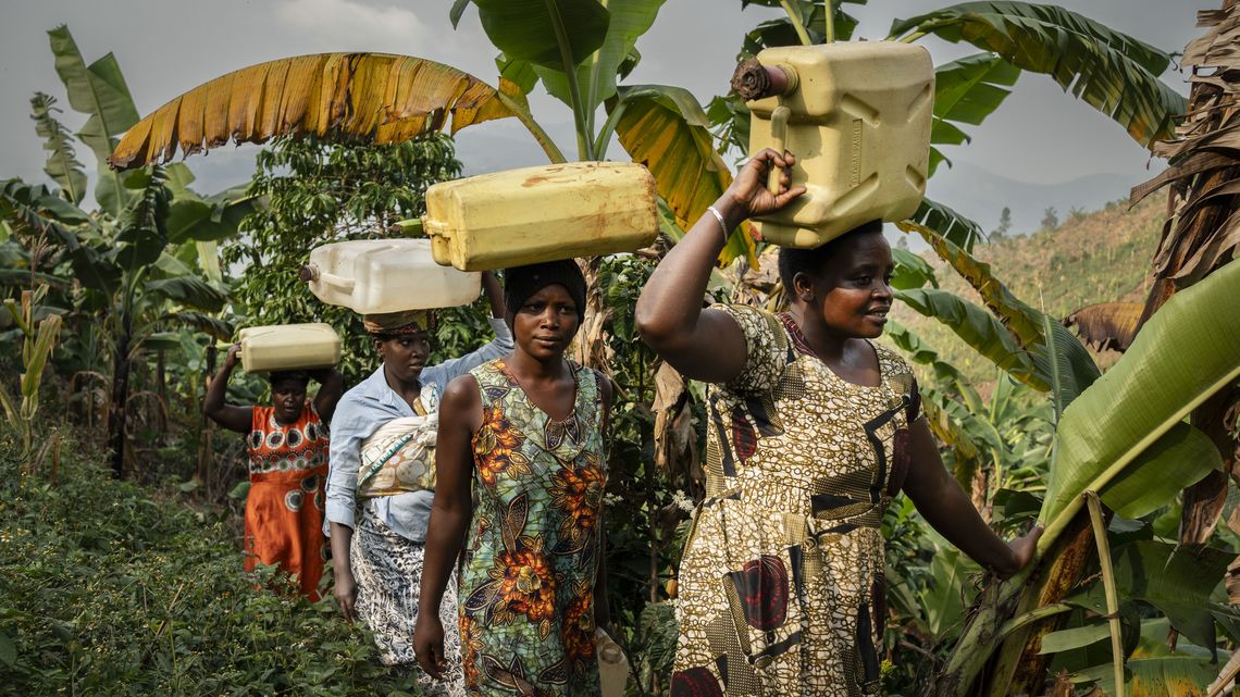 Frauen holen Wasser an einer Wasserstelle in Rwampara.