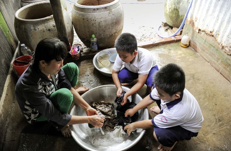 Mutter: Kam Kim Phuong (37)Zwillinge: Duong Thanh Quy (blauer Kragen)Duong Ngoc Quy , beide 8 Jahre altAsien / Vietnam / Than Tan Kommune, Mo Cay Bac District, Ben Tre Provinz