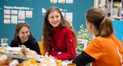 Junge Menschen informieren sich an einem Stand über Brot für die Welt