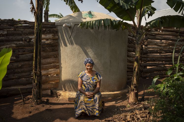 Kirabo Erabeca, 30, vor ihrem von ACORD gebauten Wassertank in ihrem Haus im Dorf Kikunda 1, Distrikt Rwampara.Projektpartner: ACORD - Agency for Cooperation in Research and Development