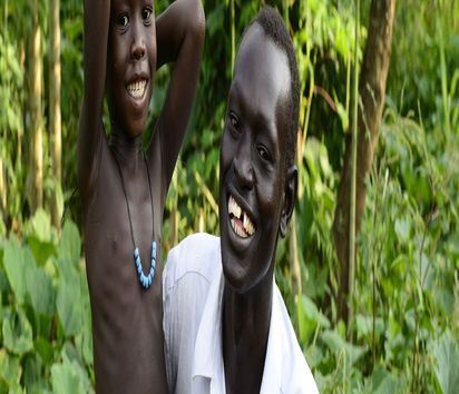 AETHIOPIEN, Gambela, Projekte EECMY-DASSC, Dorf GOG DIPACH der Ethnie ANUAK, Hof von Farmer Okello Kwot 28 Jahre und seine Frau Ariet Omot 21 Jahre, Okello und Sohn in seinem Gemuesegarten - Projektpartner Ethiopian Evangelical Church Mekane Yesus/Development and Social Service Commission (EECMY-DASSC)