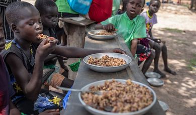 Kinder im Südsudan essen gemeinsam Hirse.
