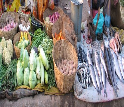 Stand eines Marktes in Indien mit Gemüse und totem Fisch