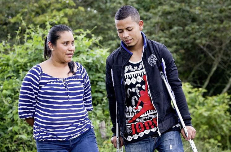 Karen Nunez (1. Person v. links, 33 Jahre), Koordinatorin von CONAMIREDIS (Komitees der rueckgekehrten Migranten mit Behinderungen), im Gespraech mit dem beidbeinig amputierten Miguel Elcides (21 Jahre).