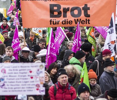 Demonstranten mit einem Brot für die Welt Banner
