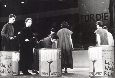 Text auf Rückseite vom original Fotoabzug:BfdW-Eröffnung 12.12.1959Kundgebung der Evangelischen Kirche und der evangelischen Freikirchen in Deutschland, in der Westberliner Deutschlandhalle. DBz: Während die Kundgebungsteilnehmer sangen, sammelten Jungen und Mädchen die Spenden für die Hungernden der Welt ein. Anschließend schütteten sie sie in große Tonnen. In diesen Tonnen sind vor Jahren in der Hungerszeit nach dem Kriege Lebensmittel als Spenden ausländischer Kirchen nach Berlin gekommen. „Dank für die empfangene Hilfe“Foto: Presse-Foto WilsonBilderdienst BfdWStafflenbergstr. 76, 7000 Stuttgart 1Kennwort: Brot-Werbung