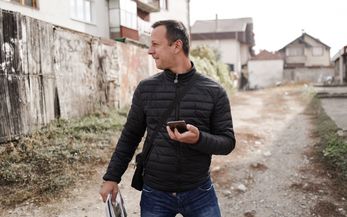 Ein Mann der mit einem Smartphone in der Hand auf der Straße steht