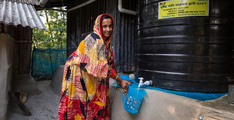 Khaleda Begum, profitiert von ihrer Regenwassergewinnung, die von CCDB gestellt wurde und kann jetzt sauberes Trinkwasser aus dem Wassertank zapfen. Die Menschen in den kleinen Siedlungen an den Fluessen in der Naehe von Shyamnagar in Sued Bangladesch, spuehren deutlich den Klimawandel. Der Meeresspiegel steigt und Daemme werden zerstört. Da durch werden Felder und die wichtigen Suesswasserteiche ueberflutet und versalzen. CCDB Bangladesch arbeitet an Suesswassergewinnungs-Projekten und sorgt dafuer, dass die Menschen nach und nach sauberes Trinkwasser erhalten.