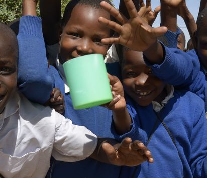 Gruppe von Schulkindern die Plastiktassen in der Hand halten 