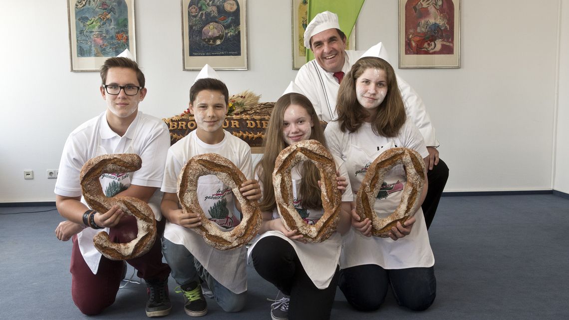 DEU, Deutschland, Berlin, 22.09.2014: Der Brandenburger Bäcker Karl-Dietmar Plentz steht mit Konfirmanden vor Broten.Unter dem Motto: „5.000 Brote – Konfis backen Brot für die Welt", startet die Aktion von Brot für die Welt mit Konfirmanden zur Unterstützung von Ausbildungsprojekten, die Brot für die Welt in Ghana, Kolumbien und Bangladesh.(Hermann Bredehorst/Brot für die Welt)|September. 22. 2014, Germany, Berlin, Berlin: 5.000 Brote – Konfis backen Brot für die Welt |